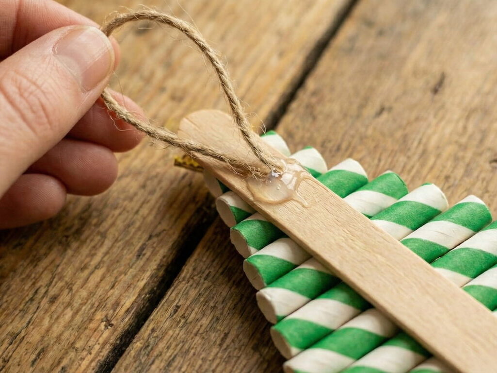 Detail zadní strany vánočního stromečku, kde je k horní části dřevěného dřívka připevněna smyčka z přírodního provázku na zavěšení.