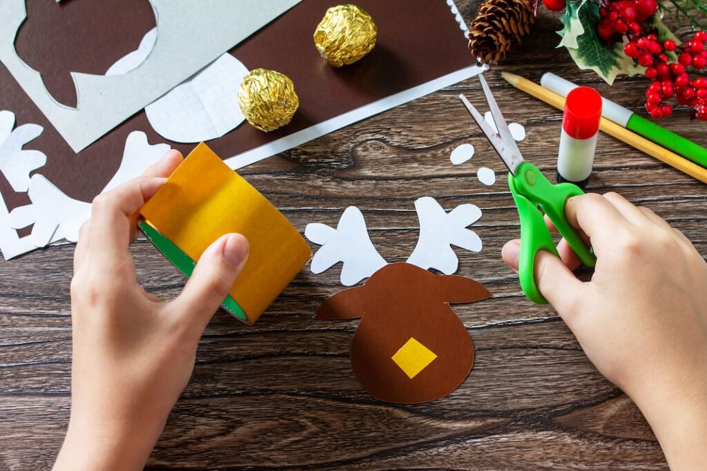 Dítě lepí čtvereček žluté oboustranné lepicí pásky doprostřed hlavy papírového soba.