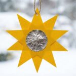 Vánoční hvězda vyrobená z papíru zavěšená na okně.