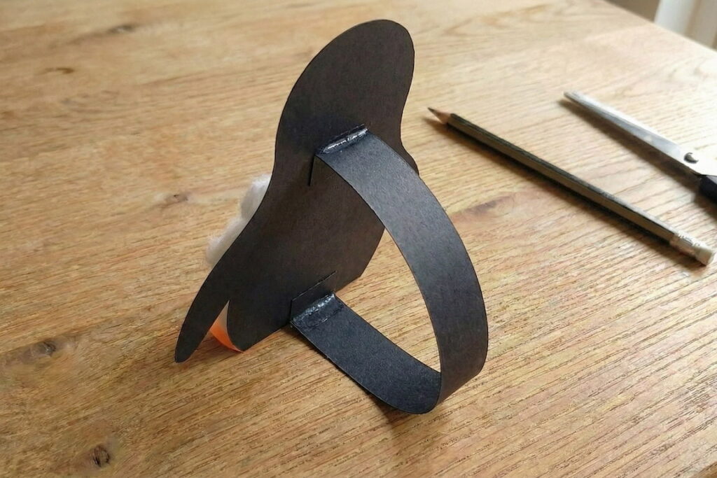 Boční pohled na papírovou opěru na zadní straně tučňáka.