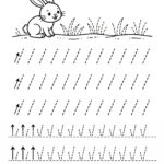 Černobílý grafomotorický pracovní list pro děti. Obsahuje kresbu zajíčka a přerušované čáry pro nácvik kreslení stébel trávy.