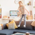 Dívka skákající po gauči